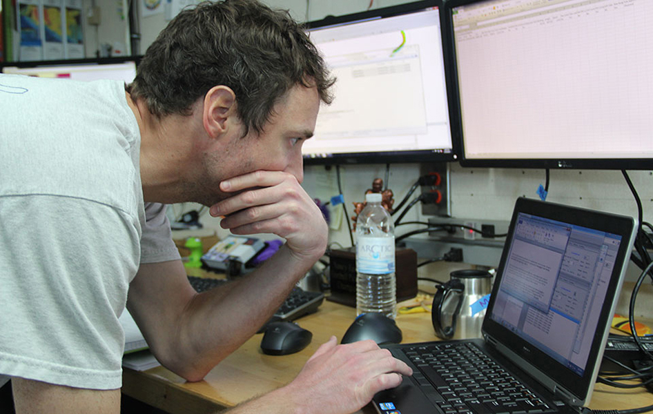 NOAA Scientist analyzing data while surveying on the NOAA Ship Ferdinand Hassler