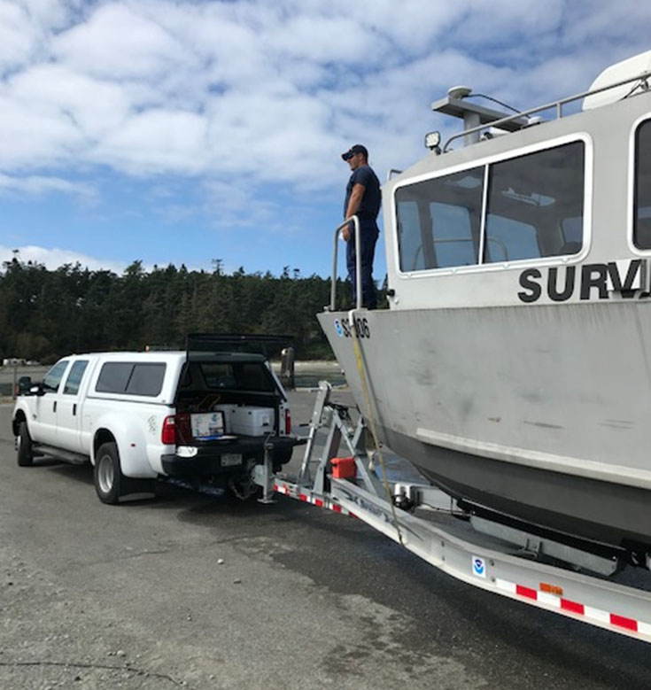Lt. j.g. Joshua Fredrick on trailered survey response vessel.